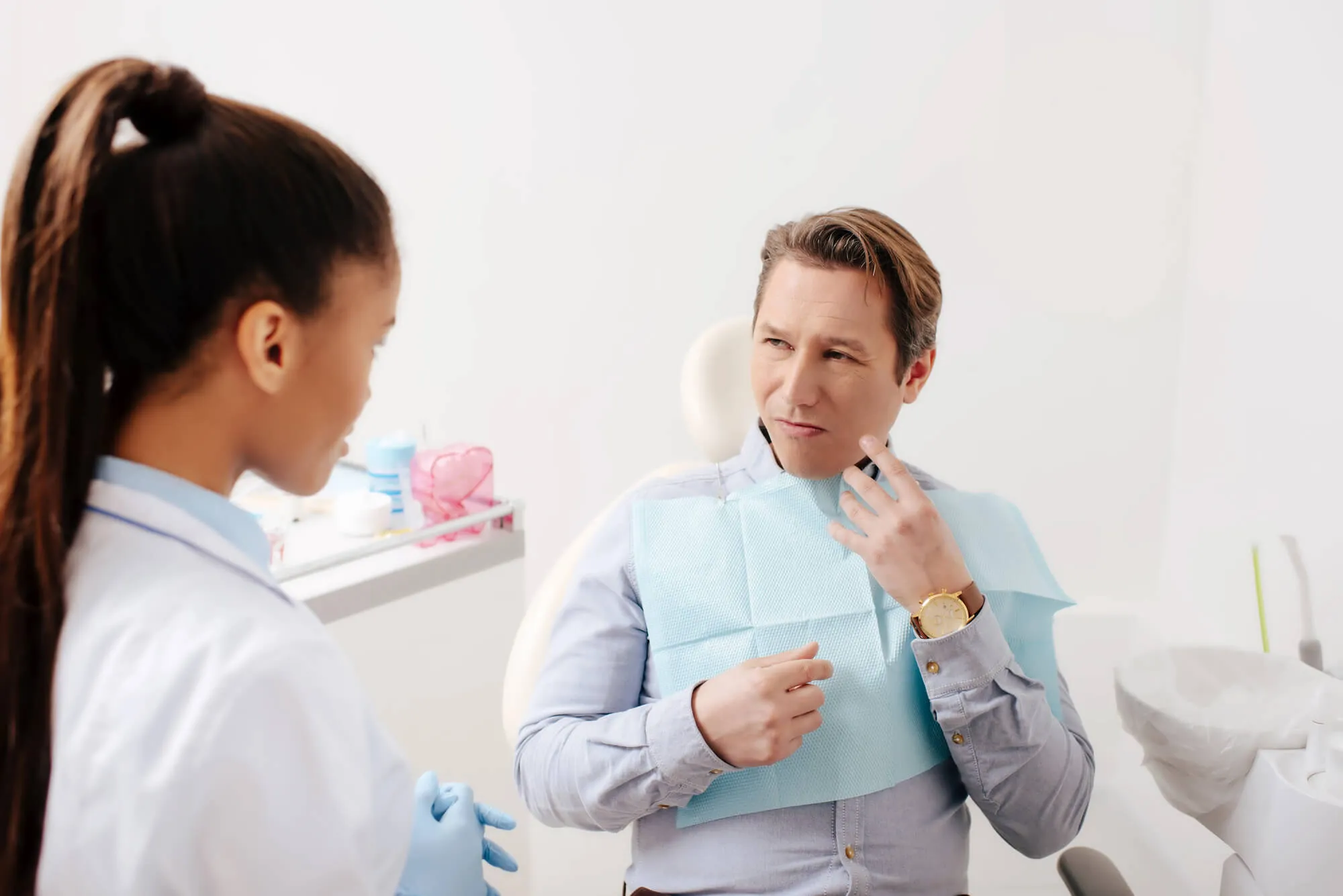 man-explaining-his-symptoms-to-an-emergency-dentist-charlotte
